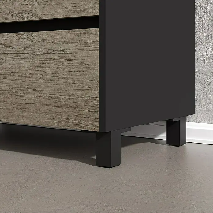 Artysan Conjunto de mueble de baño Africa - Ancho: 80 cm, 3 pzs., Nebraska, Mate - Primer plano de un mueble moderno en gris y aspecto de madera con patas negras. El mueble está sobre un suelo gris contra una pared con textura.