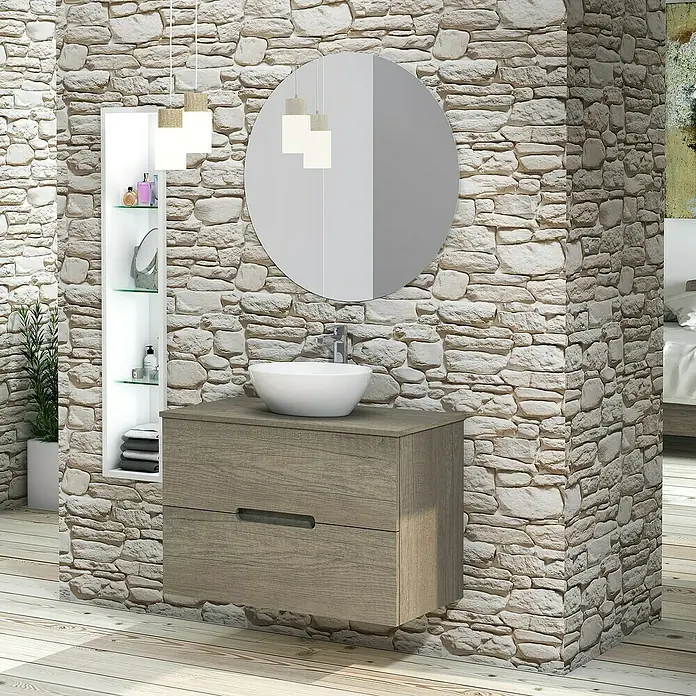 Artysan Conjunto de mueble de baño Loop Top - Ancho: 80 cm, 4 pzs., Nebraska, Mate - Instalación de baño con mueble bajo lavabo, lavabo sobre encimera y espejo redondo frente a pared de piedra. Ambiente elegante.