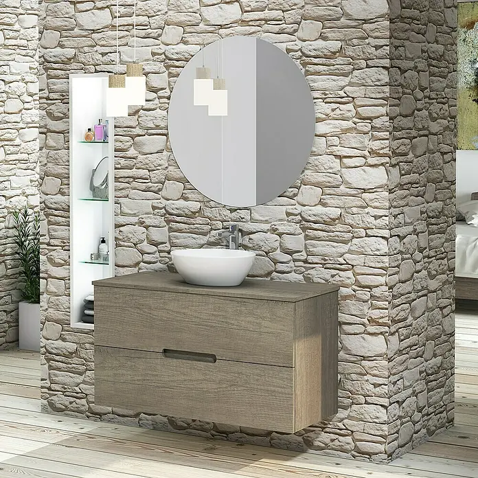 Artysan Conjunto de mueble de baño Loop Top - Ancho: 100 cm, 4 pzs., Nebraska, Mate - Mueble de baño con dos cajones, espejo redondo y estante integrado frente a una pared de piedra para un ambiente moderno.