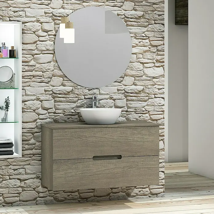 Artysan Conjunto de mueble de baño Loop Top - Ancho: 100 cm, 4 pzs., Nebraska, Mate - Un elegante lavabo de baño con espejo redondo y mueble de madera sobre pared de piedra. Diseño de baño moderno.