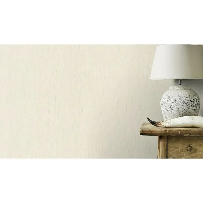 Rasch Selection Vliestapete I - Weiß, Uni, 10,05 x 0,53 m - Eine Nahaufnahme eines Tischs mit einer Lampe und einem Horn, das die Textur und die neutralen Farben des Produkts hervorhebt.