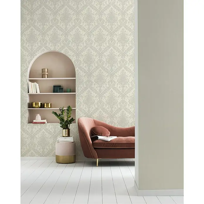 Rasch Saphira Vliestapete Barockornament - Weiß, Ornament, 10,05 x 0,53 m - Nahaufnahme eines eleganten Interieurs mit einer stilvollen Couch vor einer verzierten Tapete und einem Bücherregal.
