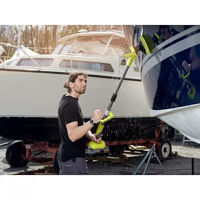 Ryobi ONE+ Cepillo rotativo de lavado R18TPS‐120G - 18 V, Iones de litio, 2 Ah - Hombre limpiando un barco con un cepillo de limpieza motorizado amarillo y gris con chorro de agua.