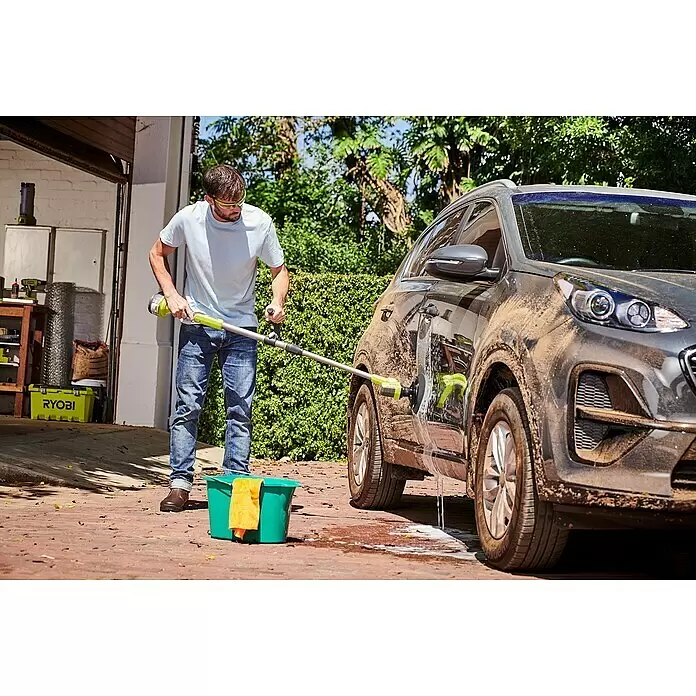 Ryobi ONE+ Cepillo rotativo de lavado R18TPS‐120G - 18 V, Iones de litio, 2 Ah - Hombre limpia un coche gris oscuro embarrado con un cepillo eléctrico verde y plateado.