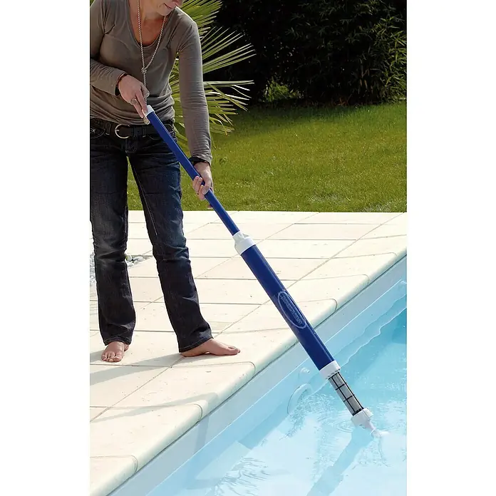 Zodiac Aspirador para piscina Spa Wand - Manual - Mujer limpiando piscina con pértiga telescópica. El limpiador de piscinas elimina suciedad y residuos para una experiencia limpia.