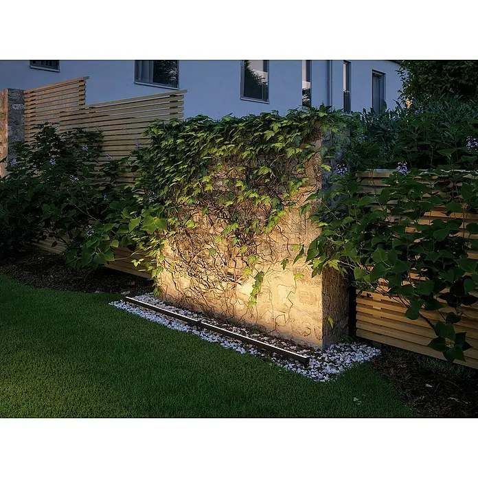 Paulmann Plug & Shine LED-Außenleuchte - 8 W, Warmweiß, IP67, L x B x H: 85,6 x 5,2 x 5,8 cm - Beleuchtete Gartenmauer mit Kletterpflanzen und seitlichen Holzelementen. Das Licht betont die natürliche Textur des Steins und das Grün.