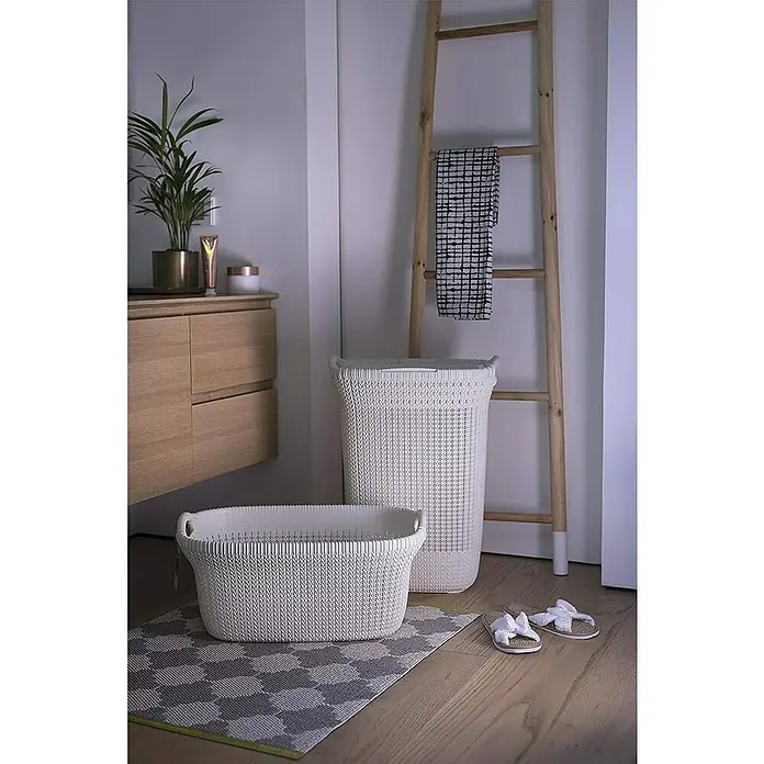 Curver Knit Cesta para la ropa - 57 l, Blanco, Plástico - Foto luminosa de baño con cestos de ropa blancos y escalera de madera, destacando las soluciones de almacenamiento.