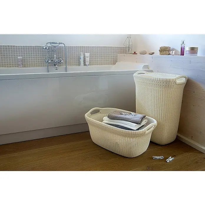 Curver Knit Cesta para la ropa - 57 l, Blanco, Plástico - Un baño con una bañera y dos cestos de ropa de mimbre, uno de los cuales está lleno de ropa.