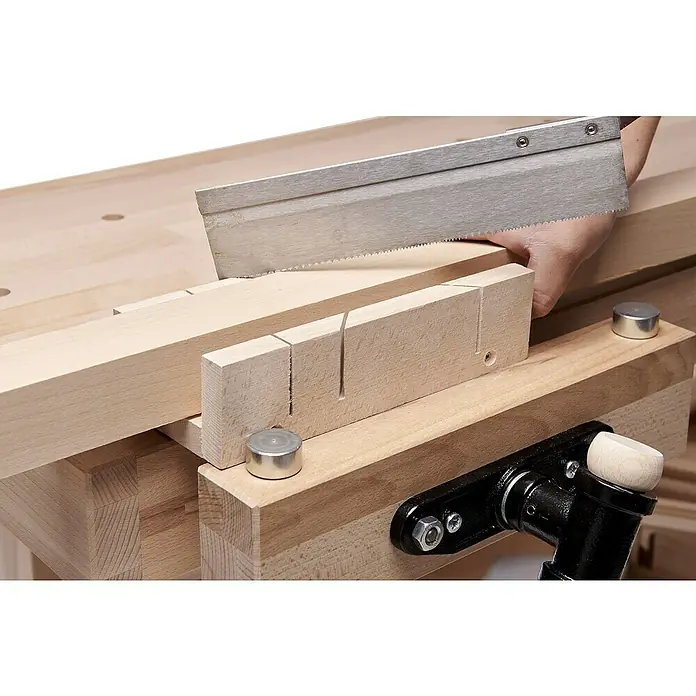 Ramia Hobelbank Advanced 2000 - L x B: 2.000 x 650 mm, Arbeitshöhe: 850 mm, Holz - Die Werkbank im Einsatz: Eine Handsäge schneidet präzise ein Holzstück, geführt durch eine Gehrungslade für exakte Schnitte.