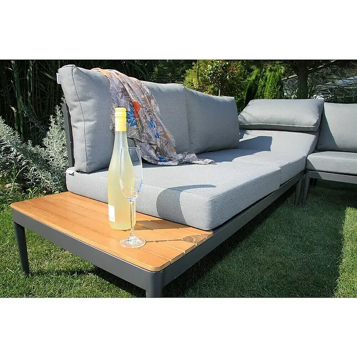 Acamp Loungemöbel-Set Paros - 4 -tlg., Akazie, Anthrazit, Braun, Silbergrau - Graue Loungegarnitur mit Weinflasche und Glas auf dem Holztisch, umgeben von Grün. Entspannung im Garten mit stilvollen Möbeln.