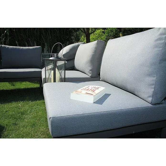 Acamp Loungemöbel-Set Paros - 4 -tlg., Akazie, Anthrazit, Braun, Silbergrau - Detailaufnahme eines grauen Outdoor-Sofas mit einem Buch von Arne Dahl. Die bequeme Sitzgelegenheit lädt zum Entspannen im Garten ein.