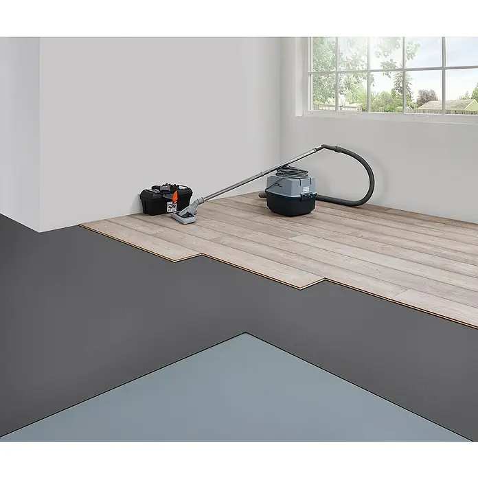 LOGOCLIC Dämmunterlage XPS Light mit Flex - 20 m², Stärke: 1,6 mm - Ein Nass-/Trockensauger steht auf einem unfertigen Holzboden neben einem Werkzeugkasten. Es gibt auch einen Blick aus dem Fenster.