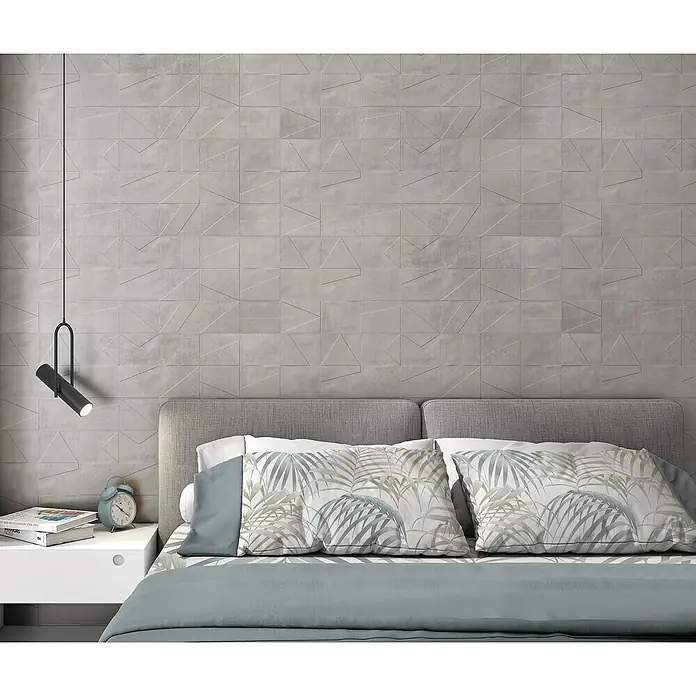 Revestimiento de pared Madox City - 90 x 30 cm, Gris, Mate, Rectificado - Primer plano de un dormitorio con pared decorativa, lámpara de noche y almohadas con estampados de hojas para un ambiente tranquilo.