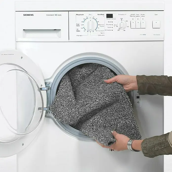Astra Fußmatte Entra SaugaktivUni, Anthrazit, 60 x 75 cm, Material Nutzschicht: 100 % Baumwolle - Eine SIEMENS Waschmaschine "SIWAMAT XS 1045" wird mit einem grauen Teppich beladen.