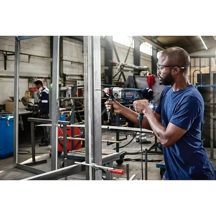 Bosch Broca para metal PointTeQ - 10 ud., Diámetro de la broca: 1,4 mm - Un hombre con gafas de seguridad perfora una pieza de metal con un taladro Bosch GSB 21-2 RE.