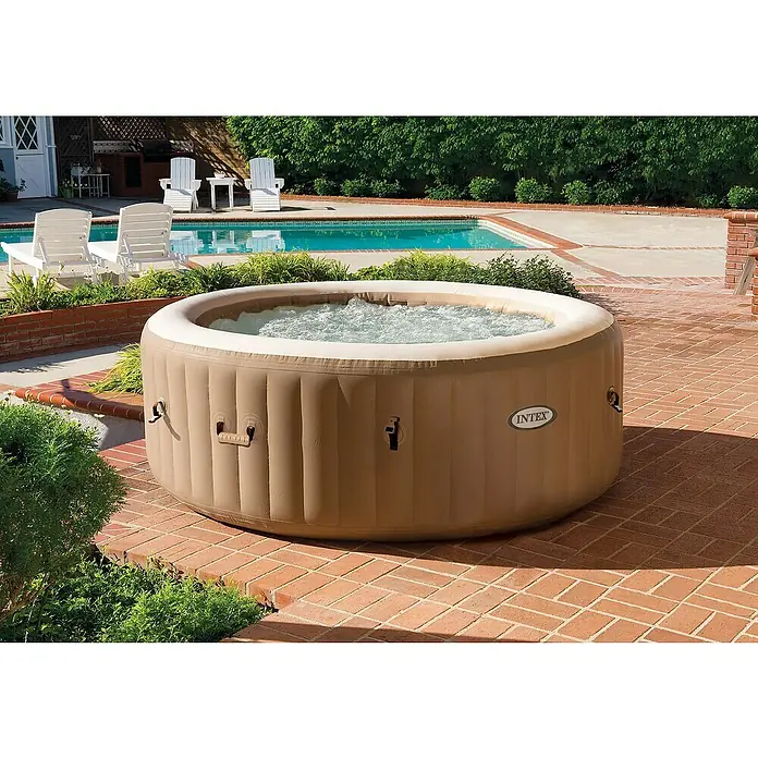 Intex Pure Spa Hidromasaje móvil Bubble - Ø x Al: 196 x 71 cm, Beige/Blanco, 800 l - Primer plano de un jacuzzi Intex al aire libre, perfecto para la relajación. Está situado en un patio junto a una piscina refrescante.