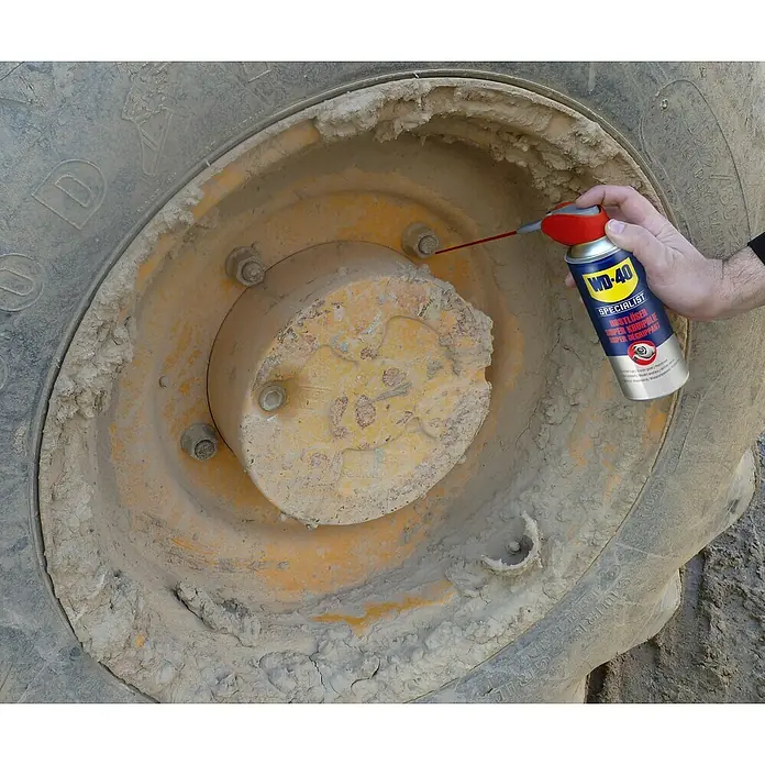 WD-40 Specialist Hochleistungs-Rostlöser Smart Straw - 250 ml - Detailaufnahme eines WD-40 SPECIALIST Rostlöser Super Kriechöl Sprays in Aktion an einem verschmutzten Traktorreifen.