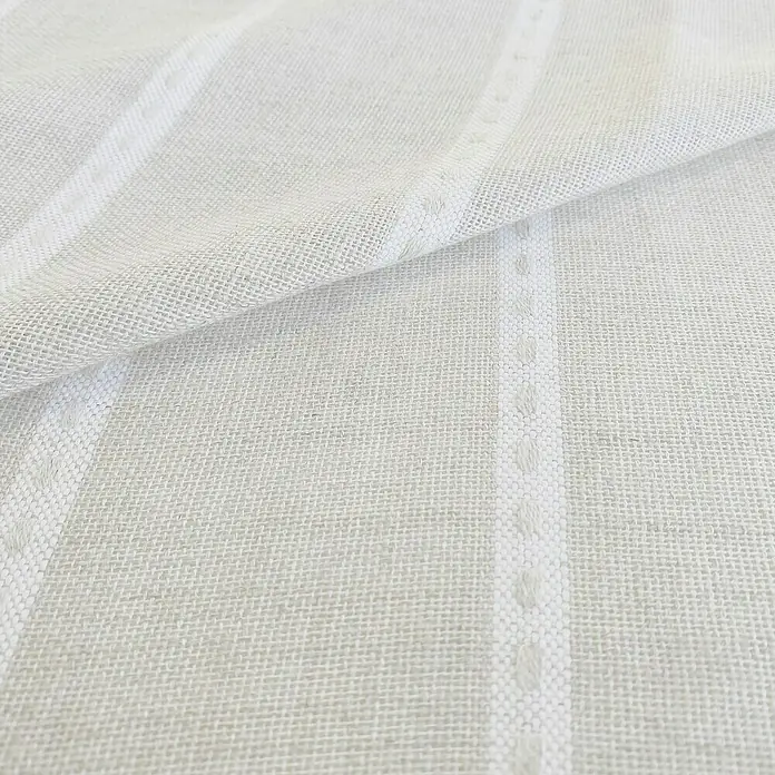 Visillo para ventana Susu - 140 x 270 cm, 65% Poliéster 35% Lino, Blanco - Primer plano de un tejido de lino blanco con un patrón de rayas, transmitiendo una estética textil y natural.