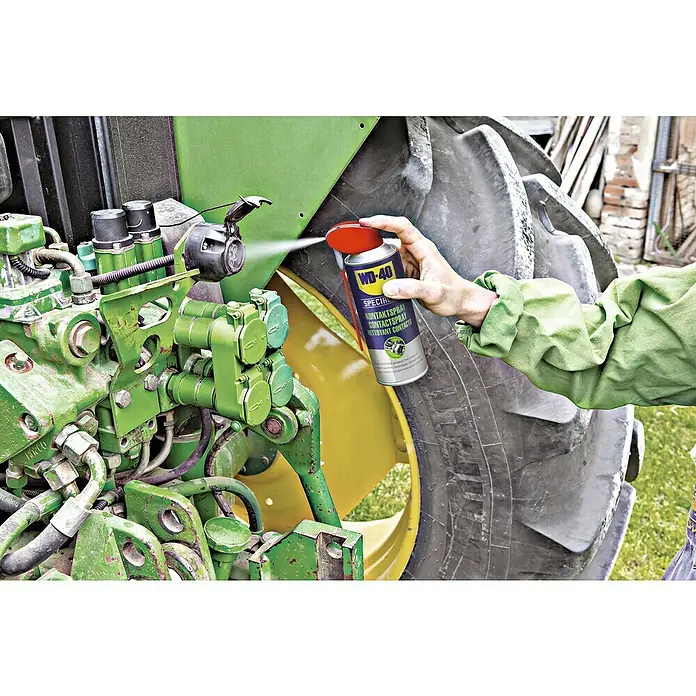 WD-40 Specialist Kontaktspray Smart Straw - 300 ml - Ein Mann sprüht WD-40 Kontaktspray auf einen Traktor, um elektrische Kontakte zu reinigen und Korrosion zu verhindern.