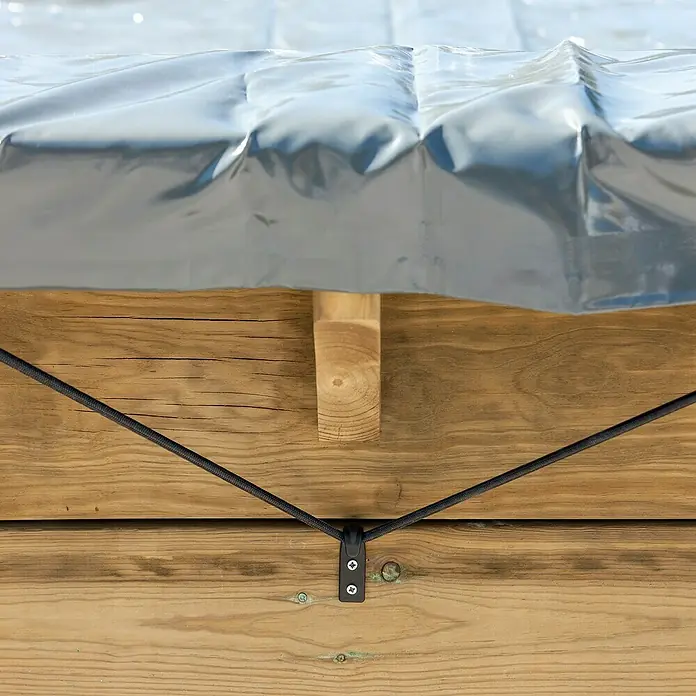 Gre Pool-Abdeckplane Winter - L x B: 658 x 360 cm, Kunststoff - Nahaufnahme einer Poolabdeckung aus grauem Kunststoff, die mit einem schwarzen Seil und einer Halterung an einer Holzterrasse befestigt ist.