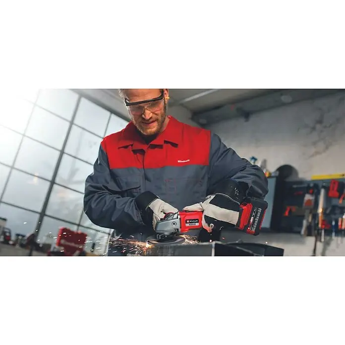Einhell Professional PXC 18V Amoladora angular de batería Axxio 18/125 Q - Sin batería, Diámetro disco: 125 mm, 8.500 r.p.m. - Un hombre con gafas de seguridad usa una amoladora angular inalámbrica Einhell para esmerilar metal, con chispas volando.