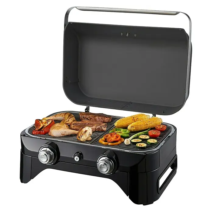 Campingaz Gasgrill Attitude 2100 LX - Grillfläche (B x T): 58 x 36 cm, 5 kW, Anzahl Brenner: 2 - Ein tragbarer Grill mit aufgeklapptem Deckel, auf dem Fleisch, Gemüse und Mais gegrillt werden, steht auf einem Tisch.