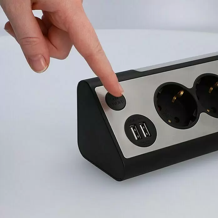 Tischsteckdose - 3-fach, Silber/Schwarz, 28 x 10,2 x 9 cm - Eine Hand drückt den 'Light ON/OFF'-Knopf an einer schwarz-silbernen Steckdosenleiste mit USB-Anschlüssen.