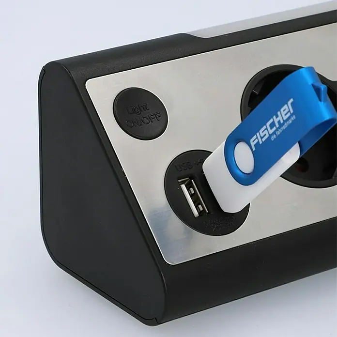 Tischsteckdose - 3-fach, Silber/Schwarz, 28 x 10,2 x 9 cm - Steckdosenleiste mit USB-Anschluss und eingestecktem USB-Stick. Die Steckdosenleiste ist schwarz, silber und hat einen Lichtschalter.