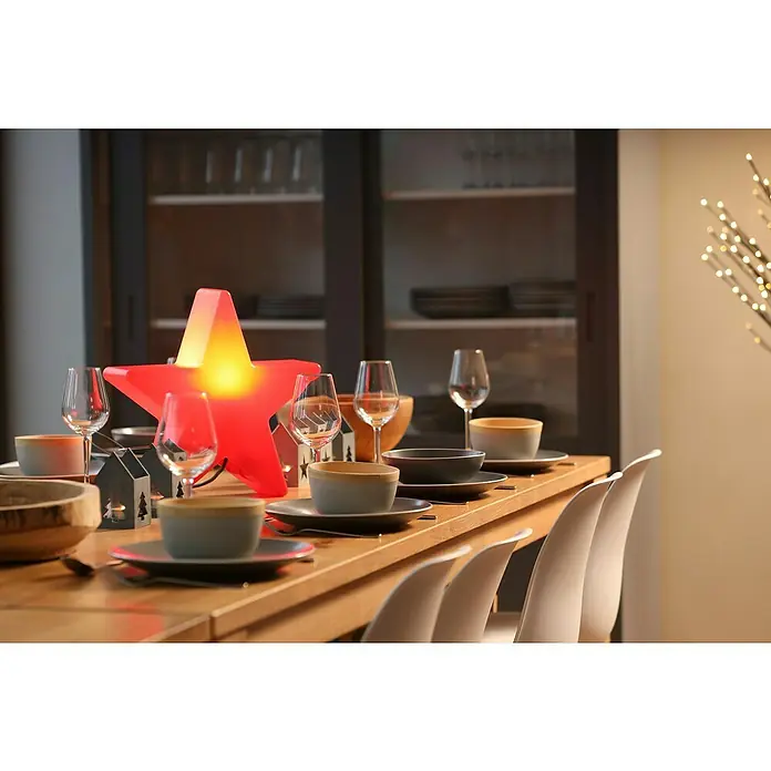 8 Seasons Design Shining Leuchtstern Star Mini - 9 W, Rot, L x B x H: 10 x 40 x 37 cm - Festlich gedeckter Tisch mit Sternlampe, Geschirr und Gläsern vor einem Schrank.