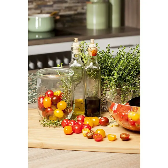 Piardino Tomate - Solanum lycopersicum, 14 cm, Erntezeit: Juli, Orange - Ein Arrangement mit kleinen Tomaten, Olivenöl und Balsamico auf einem Küchentisch.