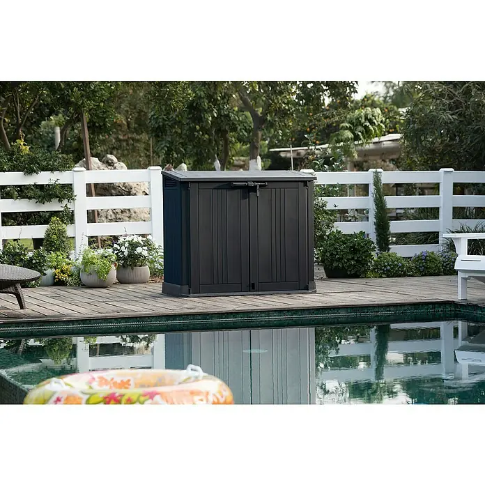 Keter Truhe Store it out Prime - L x B x H: 132 x 71,5 x 113,5 cm, Grau/Schwarz, Kunststoff - Der Fokus liegt auf einem abschließbaren, schwarzen Gartenschrank neben dem Pool, ideal zur Aufbewahrung von Poolzubehör.