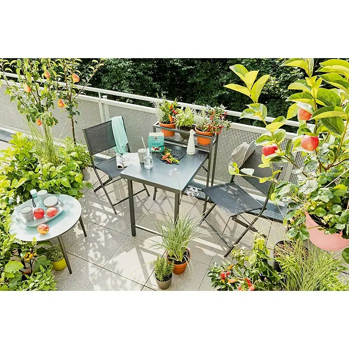 Sunfun Maja Balkonmöbel-Set - 3 -tlg., Anthrazit - Ein stilvoller Balkon mit einem grauen Gartentisch und zwei Stühlen, umgeben von üppigen Pflanzen und kleinen Apfelbäumen.