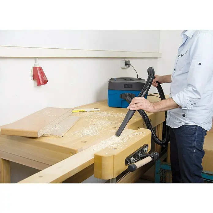 Scheppach Absauganlage HD2P - Max. Luftleistung: 120 m³/h, Füllmenge: 5 l, 1.250 W - Werkstattsauger Scheppach saugt Holzspäne von einer Werkbank auf, wodurch die Arbeitsfläche sauber bleibt.