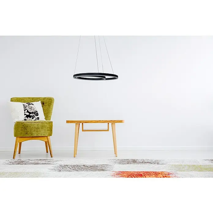 Direct Signs LED-Pendelleuchte Noble - Höhe: 150 cm, Schwarz, Durchmesser: 600 mm - Elegante Wohnzimmerszene mit einem modernen, kreisförmigen Pendelleuchte über einem Holztisch und einem grünen Sessel mit Kissen.