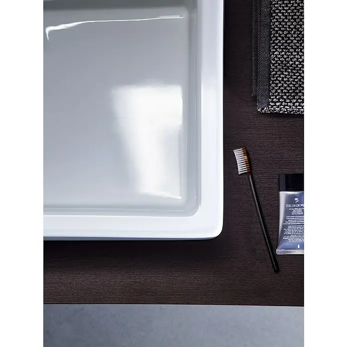 Duravit Vero Waschtisch - 80 x 47 cm, Mit schmutzabweisender Glasur, Hahnloch: Mitte, Mit Überlauf, Weiß, Ungeschliffen - Aufsicht auf ein Badezimmerwaschbecken mit Seife, Zahnbürste, Zahnpasta und einem Waschlappen, minimalistisch und modern.