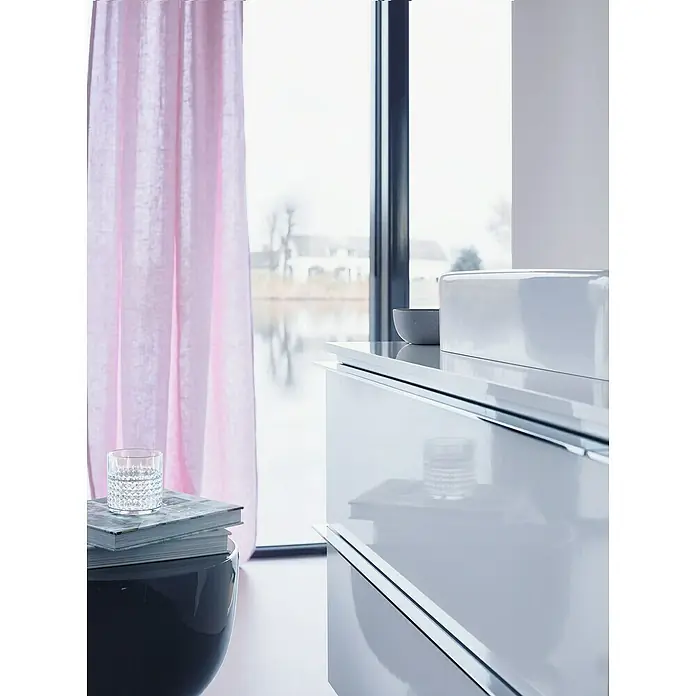 Duravit Happy D.2 Aufsatzwaschbecken - 60 x 46 cm, Ohne Spezialglasur, Hahnloch: Mitte, Mit Überlauf, Weiß - Elegantes Interieur mit einem weißen Waschtisch, einem stilvollen Beistelltisch und zarten rosa Vorhängen, die für eine ruhige Atmosphäre sorgen.
