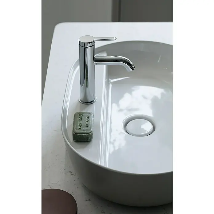 Duravit Luv Aufsatzwaschbecken - 80 x 40 cm, Ohne Spezialglasur, Hahnloch: Mitte, Ohne Überlauf, Weiß Seidenmatt - Nahaufnahme eines modernen Waschbeckens mit Armatur, Seife und Abflussstopfen, das ein elegantes Badezimmerdesign hervorhebt.