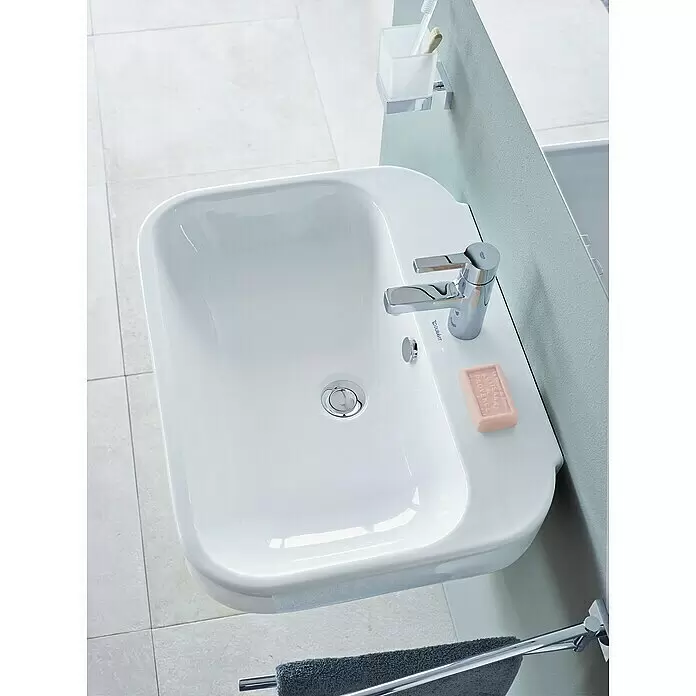 Duravit Happy D.2 Waschtisch Typ 3 - 65 x 49,5 cm, Ohne Spezialglasur, Mit Hahnloch, Mit Überlauf, Weiß - Weißes rechteckiges Waschbecken mit Chromarmatur, rosa Seife und Zahnbürstenhalter.
