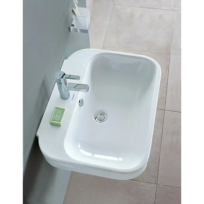 Duravit Happy D.2 Waschtisch Typ 3 - 65 x 49,5 cm, Ohne Spezialglasur, Mit Hahnloch, Mit Überlauf, Weiß - Aufsicht auf ein modernes, weißes Waschbecken mit Armatur, Seife und einem Behälter für Zahnbürsten an einer grauen Wand.