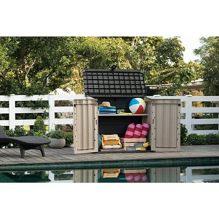 Keter Arcón Store It Out Midi - L x An x Al: 71,5 x 132 x 113,5 cm, Beige/Marrón, Plástico - Una caja de almacenamiento abierta en la piscina, llena de elementos básicos para la playa como toallas, pelotas y gafas.