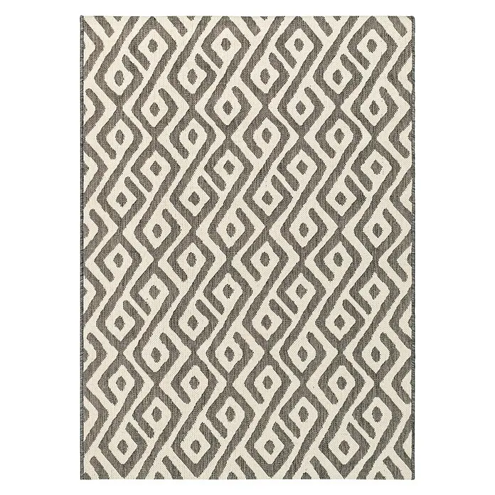 Alfombra exterior Sun Etnic - Beige/Marrón, 170 x 120 cm, 100% polipropileno (Flor) - Una alfombra rectangular con un patrón de rombos repetido en gris y blanco añade un toque moderno a la habitación.