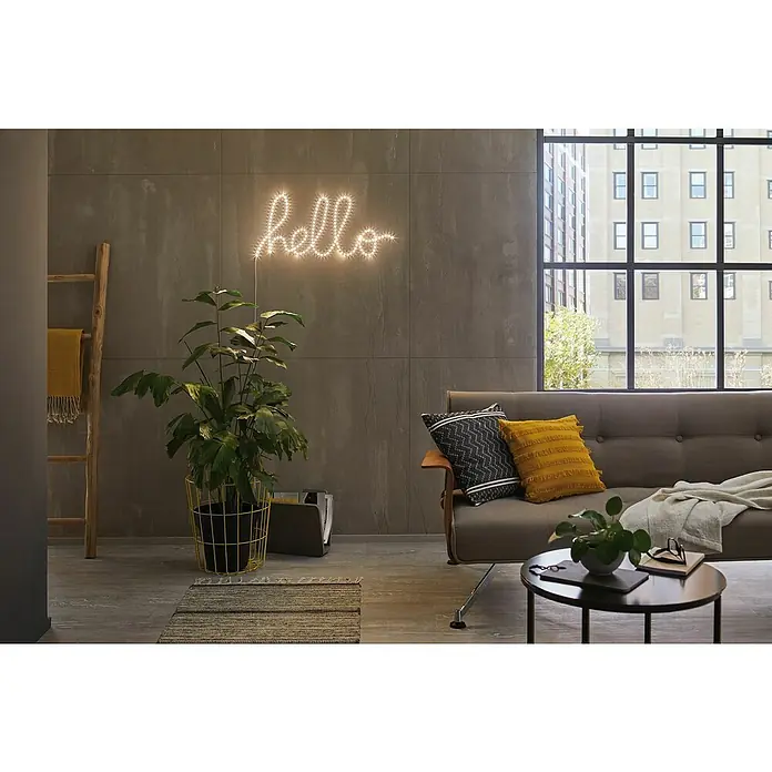Paulmann LED-Band Function FlexLED - Länge: 5 m, Lichtfarbe: Warmweiß, 10,5 W - Gemütliches Wohnzimmer mit einem grauen Sofa, Kissen und einer leuchtenden "Hallo"-Schrift an der Wand. Einladend und modern.