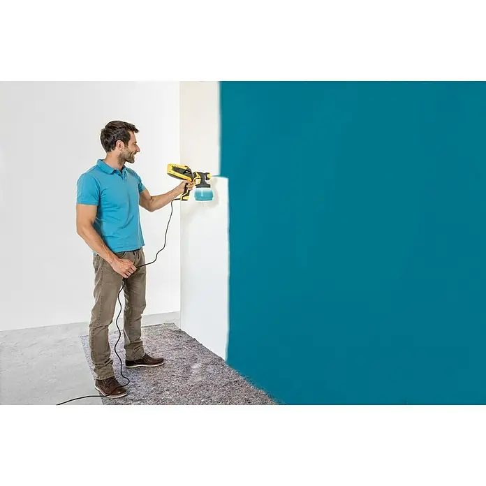 Wagner Farbsprühsystem W 590 Flexio - 630 W, Förderleistung: 0,5 l/min - Ein Mann benutzt eine Farbspritzpistole, um eine Wand blau zu streichen. Die Farbspritzpistole ist gelb und schwarz.