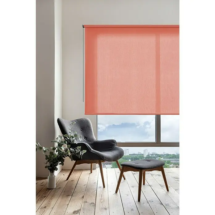 Estor enrollable Soft - An x Al: 160 x 250 cm, Arcilla - Interior elegante con un sistema doble de estores enrollables color coral que aporta privacidad y estilo. Un sillón cómodo y un reposapiés completan el espacio.