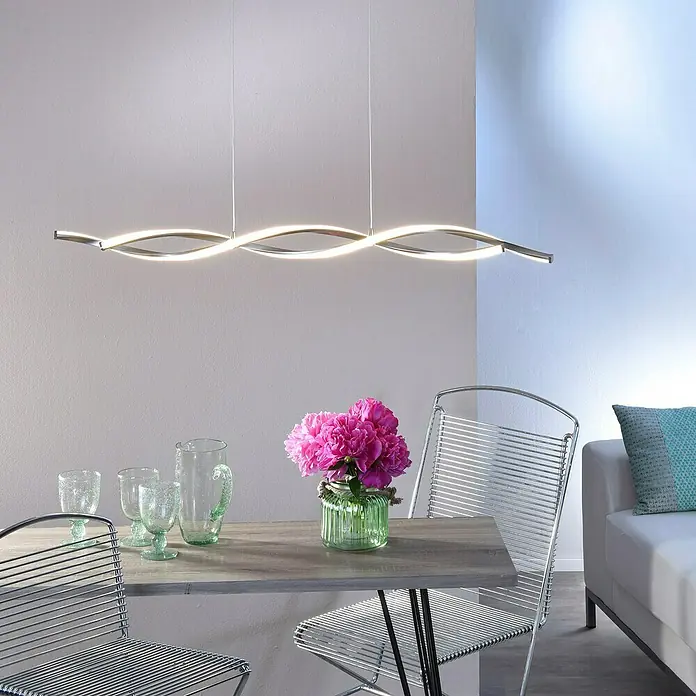 Paul Neuhaus Polina LED-Pendelleuchte - Warmweiß - Elegante LED-Hängeleuchte in einem modernen Esszimmer. Das Lichtelement schwebt über einem Holztisch mit Blumen und Gläsern.
