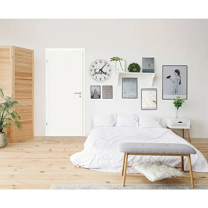 Classen PL Zimmertür - 735 x 1.985 mm, DIN Anschlag: Links, Weißlack, Wabe - Ein Schlafzimmer mit einer eleganten weißen Tür, die sich harmonisch in die helle und moderne Raumgestaltung einfügt.