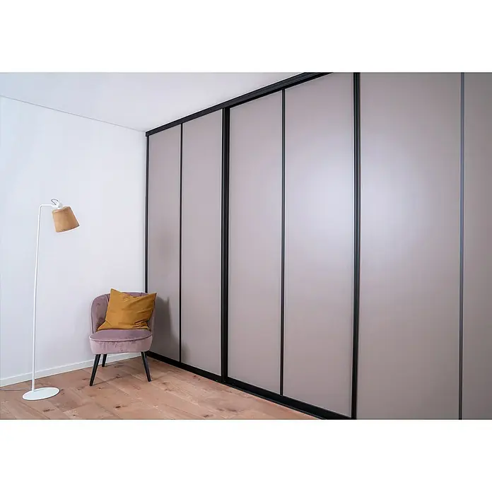 Room Plaza Easy Schiebetür-Bau-Set - Taupe/Weiß Miniperl, Farbe Beschlag: Schwarz - Ein modernes Zimmer mit einem Schrank mit Schiebetüren, einem Sessel und einer Stehlampe. Elegantes Möbeldesign für ein stilvolles Interieur.