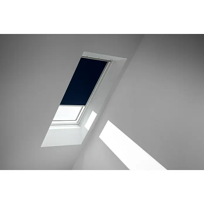 Velux Dachfensterrollo DKL C04 1100SWL - Farbe: Dunkelblau - 1100SWL, Farbe Schiene: Weiß, Manuell - Blick auf ein Dachfenster mit Rollo in einem hellen Raum. Das Rollo ist heruntergelassen und verdunkelt den Raum teilweise.