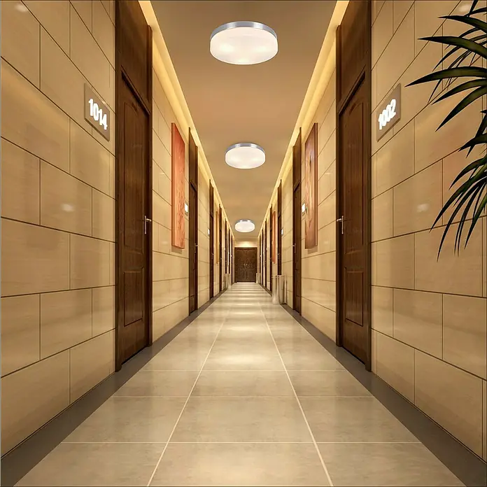 Tween Light Deckenleuchte rund Andrano - 40 W, E27 - Ein langer Hotelkorridor mit vielen Türen, beleuchtet durch runde Deckenleuchten, die eine einladende Atmosphäre schaffen.