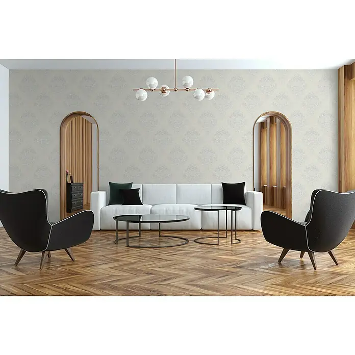 A.S. Création Metropolitan Stories II Vliestapete Damask - Creme, Ornament, 10,05 x 0,53 m - Einladendes Wohnzimmer mit einem eleganten weißen Sofa und zwei stilvollen schwarzen Sesseln. Das harmonische Design wird durch eine moderne Lampe ergänzt.